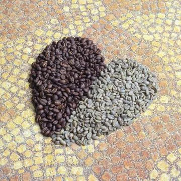 Heart shape created with roasted and unroasted coffee grains Stock Photos