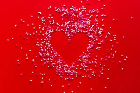 Heart shape made of candy on red background. Copy space Valentine Day concept Photos