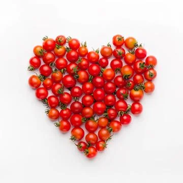 Heart shape made of cherry tomatoes on white background Stock Photos