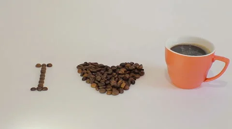 Heart shape made from coffee beans and cup of coffee Stock Footage 61448452