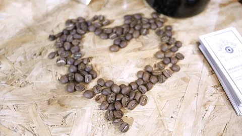 Heart shape made from coffee beans on  surface 動画素材 103542383