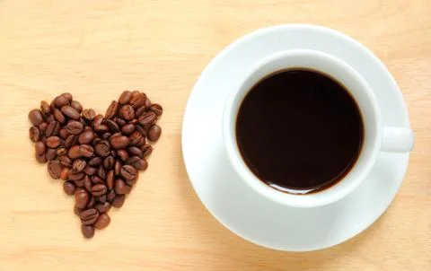 Heart shape made from coffee beans with a cup of coffee Stock-Fotos