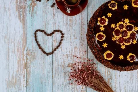 Heart shape made from coffee beans with chocolate cherry cake. Stock Photos