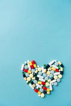 Heart shape made of different pills on blue background Stock Photos