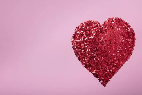Heart shape made of red glitter on pink background. Love concept. Stock Photos