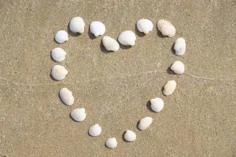 Heart Shape made of shells on the sandy beach Stock Photos