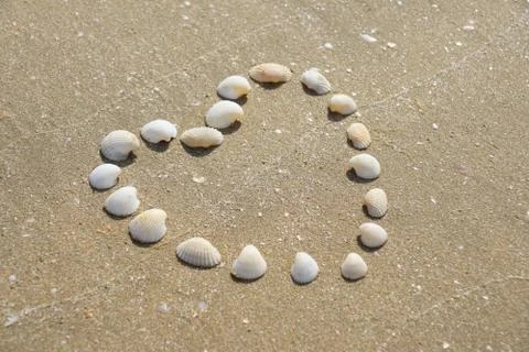 Heart Shape made of shells on the sandy beach Stock Photos