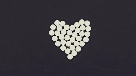 Heart Shape Made from White Tablets on Black Background Video stock 304394644