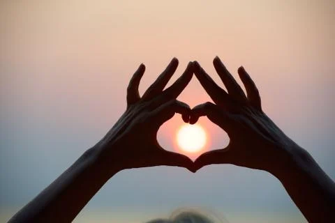 Heart shape make by hands and sea sunset Stock Photos