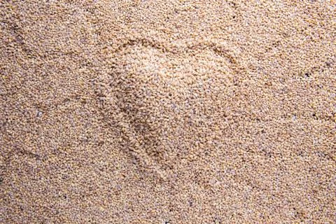 Heart shape mark with squiggly lines on Barley grain malt background Stock Photos