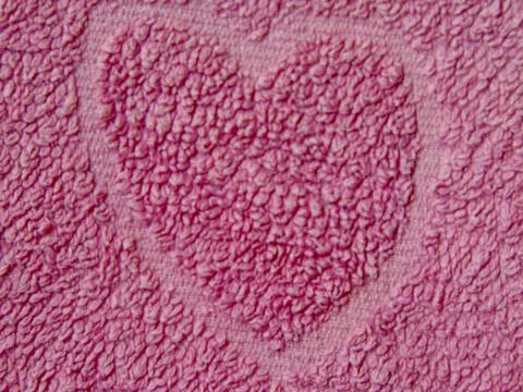 Heart shape on a pink towel Stock Photos
