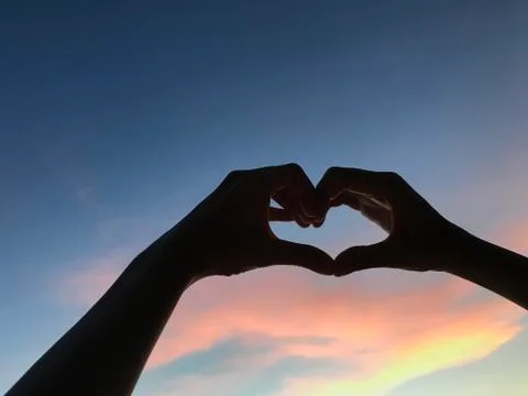 Heart shape in the sunset sky Stock Photos