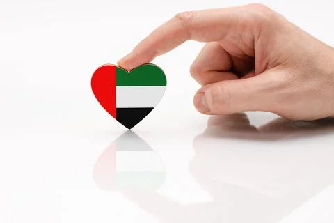 Heart in the shape of the UAE flag on a white glass surface Stock Photos