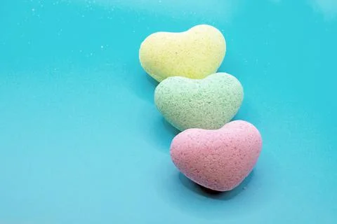 Heart-shaped bath bombs in close-up on a blue background Stock Photos