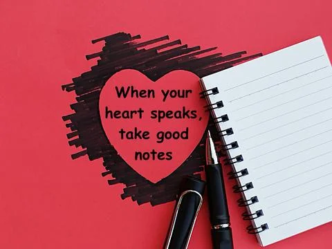 Heart-shaped black marker scribble with notebook and pen on red background Stock Photos