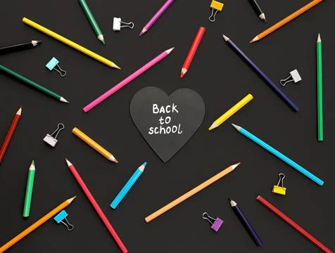 Heart shaped board with back to school inscription colored pencils in chaotic Stock Photos