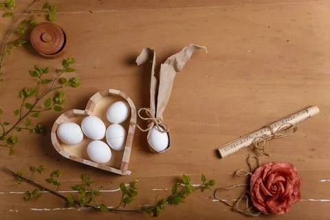 Heart shaped box with boiled eggs, salt pot, fabric rose flower and Easter bunny Stock Photos
