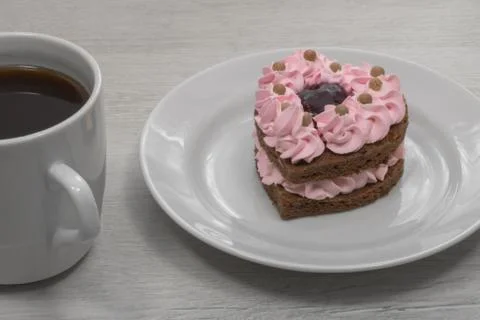 Heart shaped cake. Cake with a mug of coffee. Stock Photos