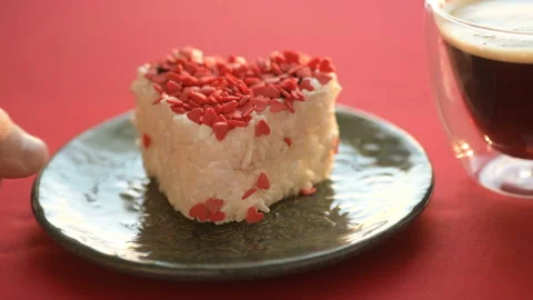 A heart-shaped cake is placed on a red tablecloth Stock Footage