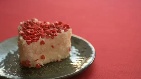 A heart-shaped cake is placed on a red tablecloth Stock Footage 147035835