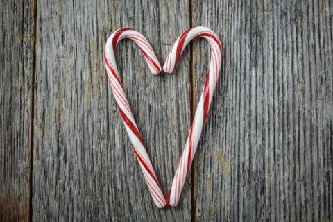 Heart shaped candy canes on a rustic wooden background Stock Photos