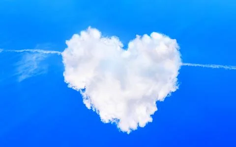 Heart shaped cloud in the sky with plane cupid arrow. Love symbol. Cloudscape Stock Photos