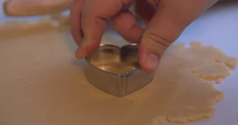 Heart Shaped Cookie Cutter Cutting into Cookie Dough Stock Footage 101051883