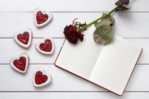 Heart shaped cookies with empty notebook frame and red rose gift composition for Stock Photos