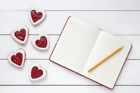 Heart shaped cookies with empty notebook frame and pencil composition for Stock Photos