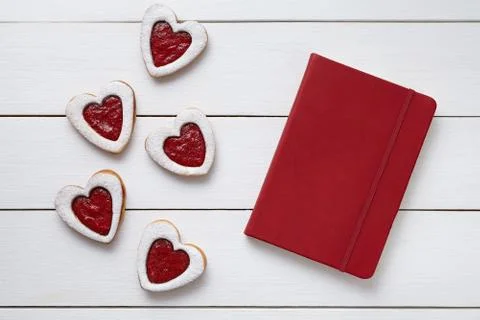 Heart shaped cookies with empty red notebook, composition on white wooden Stock Photos