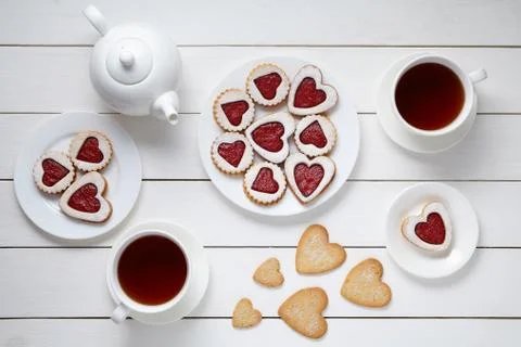 Heart shaped cookies for Valentines day with teapot and two cups of tea on white Stock Photos