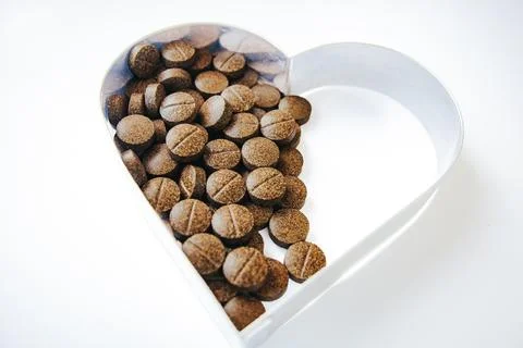 A heart shaped dish containing numerous round. Stock Photos