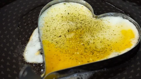 Heart shaped fried egg on black hot pan. Appetizing breakfast. 스톡 동영상 89034846