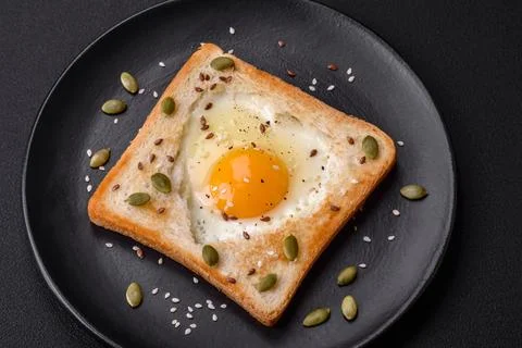 Heart shaped fried egg in bread toast with sesame seeds, flax seeds and pum.. Stock Photos
