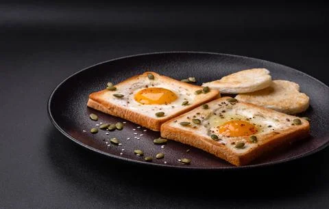 Heart shaped fried egg in bread toast with sesame seeds, flax seeds and pum.. Stock Photos