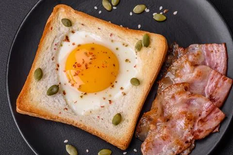 Heart shaped fried egg in bread toast with sesame seeds, flax seeds and pum.. Stock Photos