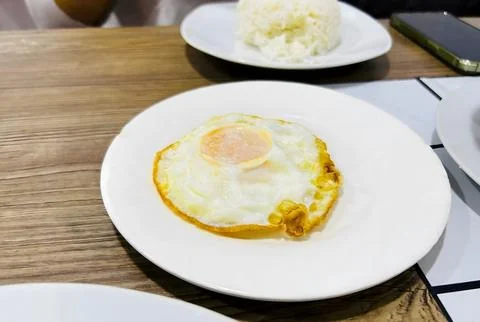Heart-shaped fried egg on a white plate. Foto stock