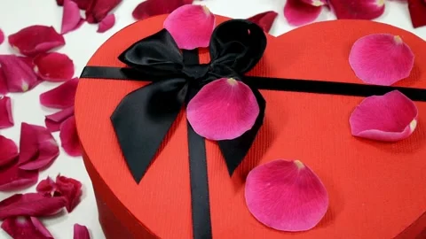 Heart shaped gift box with rose petals for Valentines Day Video stock 334572307