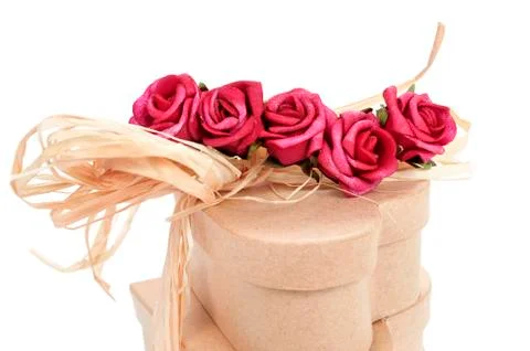 Heart-shaped gift boxes tied with natural raffia and topped with artificial r Stock Photos