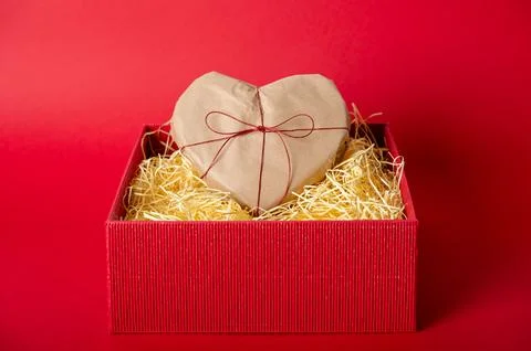 Heart shaped gift in red box with shredder paper Stock Photos