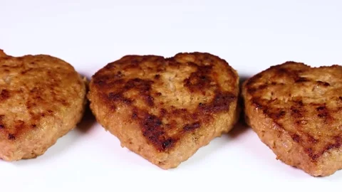 Heart-shaped hamburger steaks lined up in a row, rotating Stock Footage 320809224