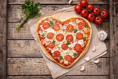 Heart shaped pizza margherita vegetarian love concept with mozzarella, tomatoes Stock Photos