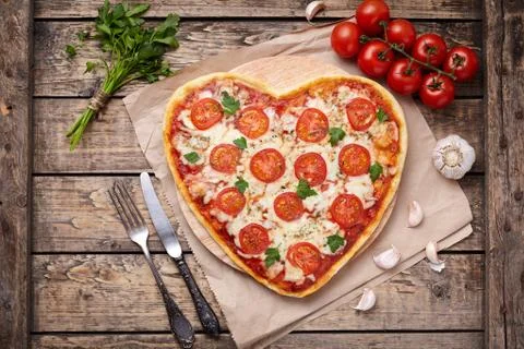 Heart shaped pizza margherita vegetarian love concept with mozzarella, tomatoes Stock Photos