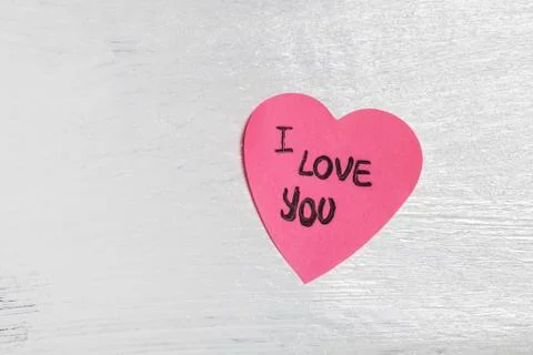 Heart-shaped post-it on the wall with love message Stock Photos
