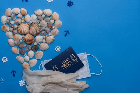 Heart-shaped shells on a blue background. Medical mask, biometric passport of Stock Photos