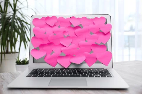 Heart shaped sticky notes on notebook at workplace. Valentine's Day celebrati Stock Photos