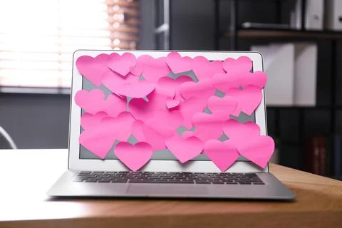Heart shaped sticky notes on notebook at workplace. Valentine's Day celebrati 스톡 사진