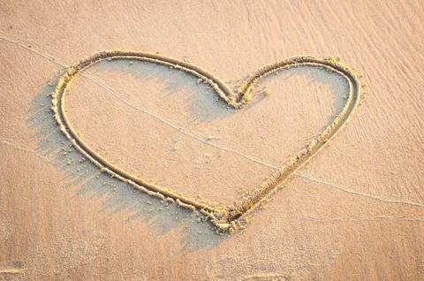 Heart sharp is drawing by hand in sand Stock Photos