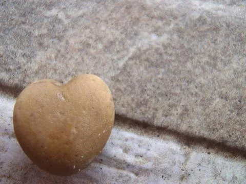 A heart of stone on a stone background Stock Photos