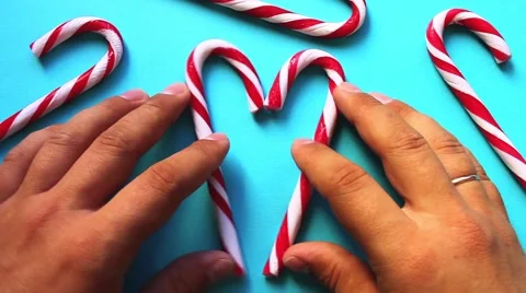 Heart of striped candy canes made by hand on a blue surface Stock Footage 68741025
